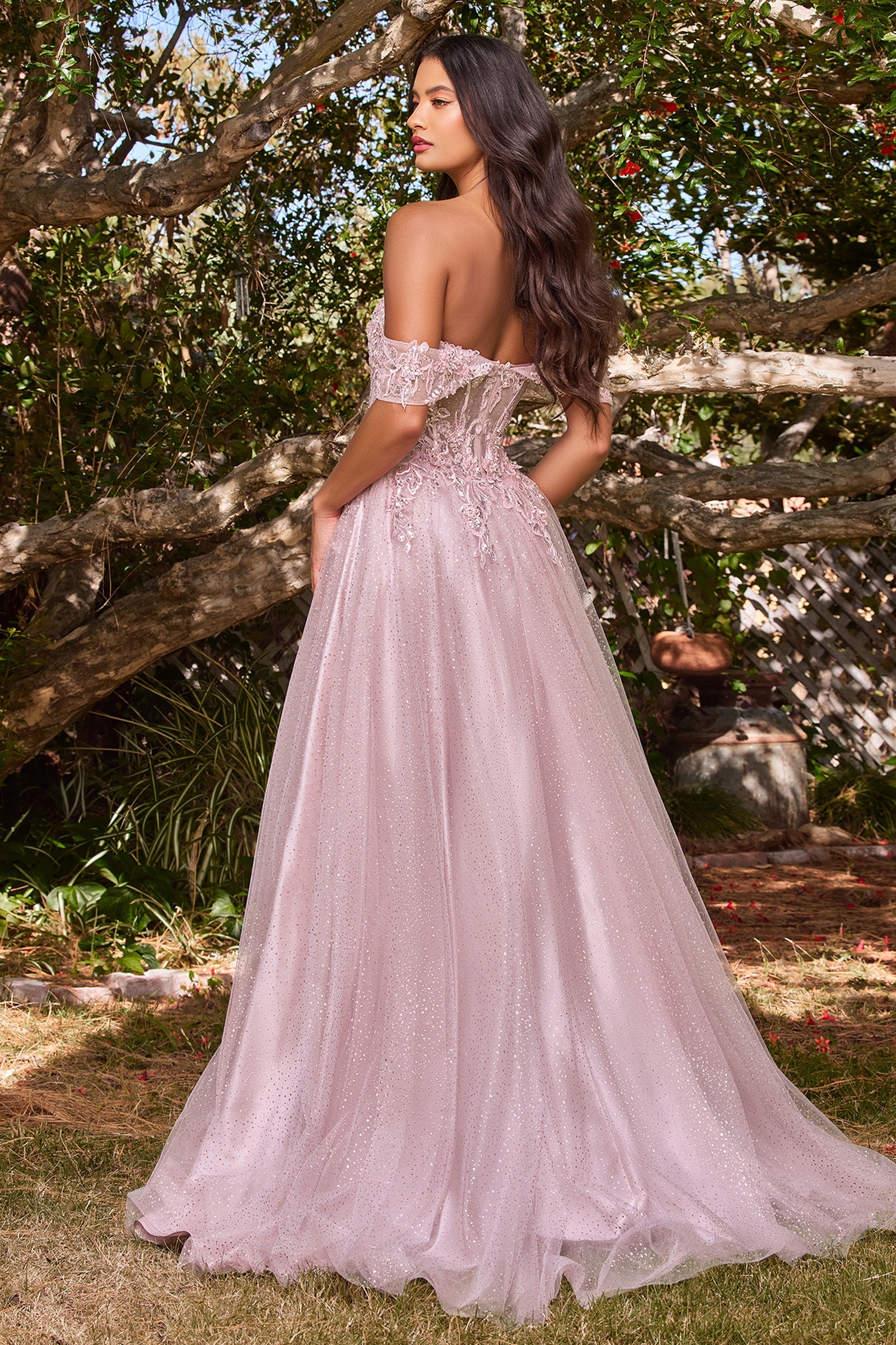A woman stands outdoors among trees, wearing the Off-Shoulder Long Glitter A-Line Prom Dress CD0198 with lace embroidery, looking over her shoulder.